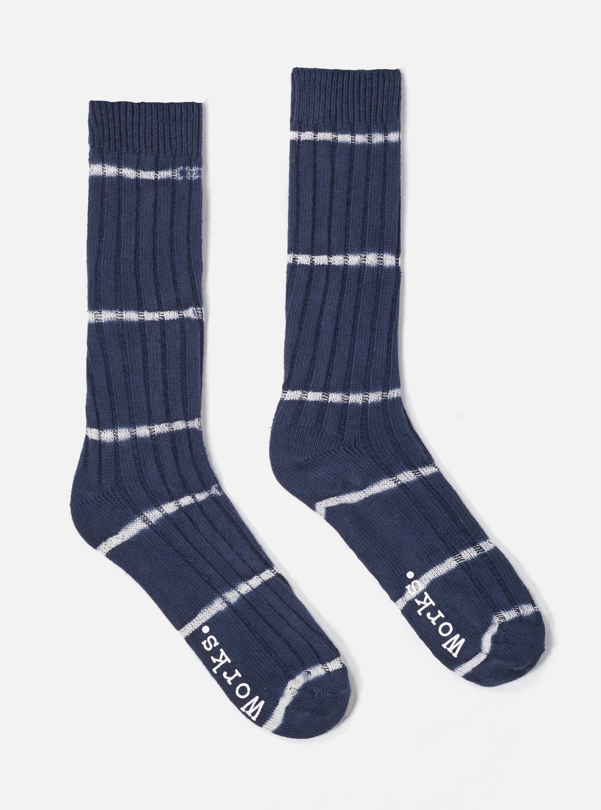 The Navy Tie Dye Knit Slub Sock, a ribbed knit sock in navy with white tie dye stripes, on a white background.
