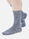 A person wearing Navy Slub Knit Slub Sock on a white background. The socks are blue and white and have a ribbed texture.