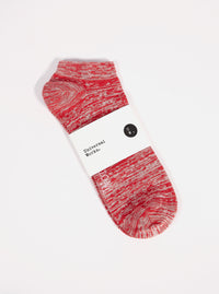 A Red Slub Knit Ankle Slub Sock on a white surface. The sock features a red and white slub knit pattern and is packaged with a white label.