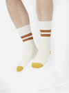 Legs wearing Ecru/Orange Cotton Rib Sport Sock on a white background. The socks are ribbed and have orange stripes and toes.