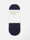 Close-up of an Ecru/Navy Cotton Mix Knit No Show Sock on a white background. The sock features navy blue ends and an ecru center with the brand name printed on it.