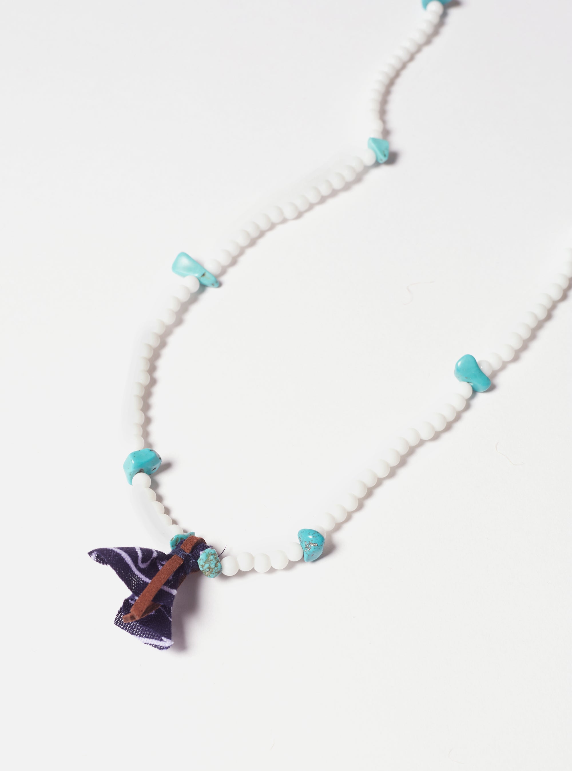 Hanami of Rome Bandana Necklace/Bracelet No.30 on a white surface. Features white beads, turquoise stones, and a navy bandana accent with brown leather.