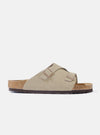 Studio shot of a Birkenstock Taupe Suede Zürich sandal on a white background. The sandal features a taupe suede upper and a cork footbed.